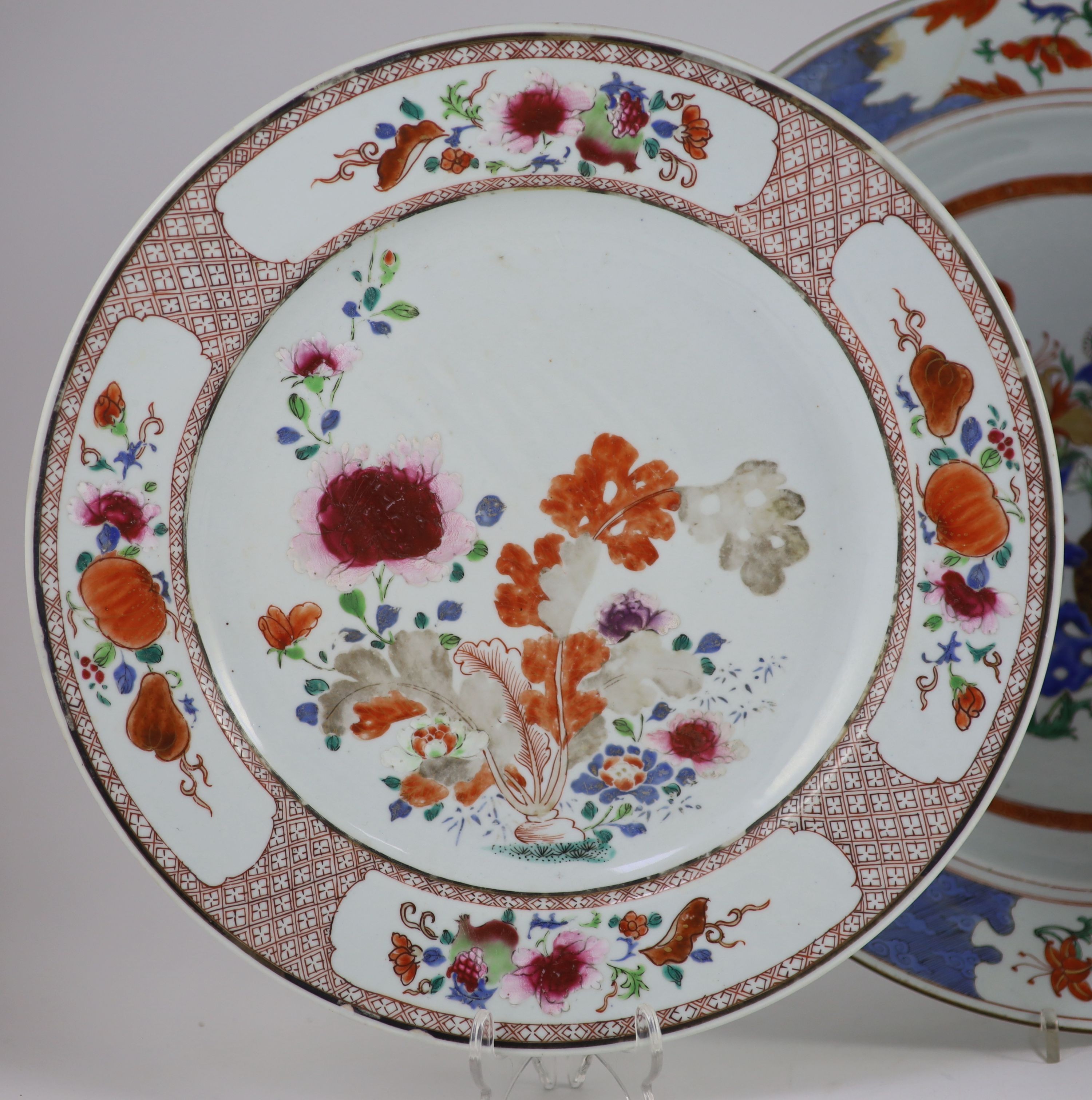 A pair of Chinese export famille rose dishes and a similar charger, early Qianlong period, diameter 35 cm and 42 cm, the charger broken and repaired